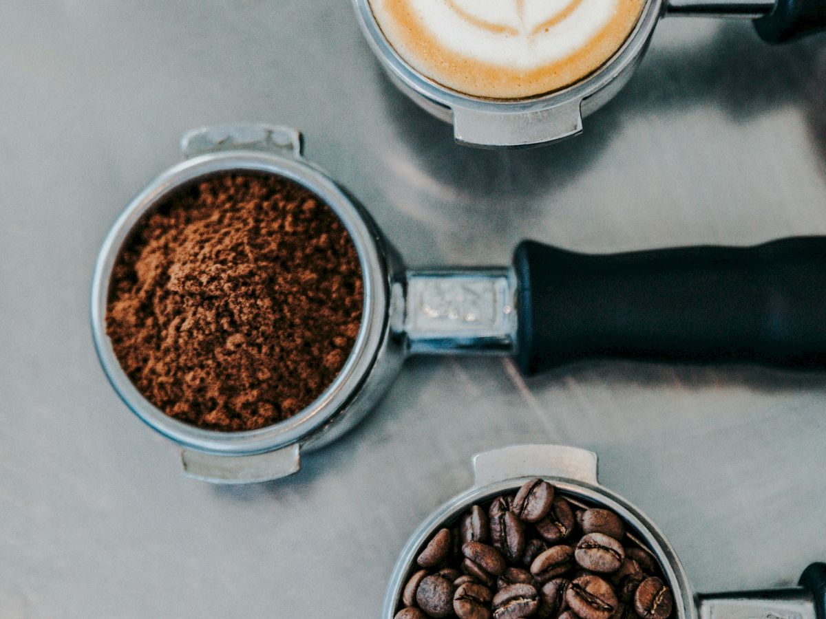 The image shows coffee progression: whole beans, ground coffee, and a latte with a leaf design on top.