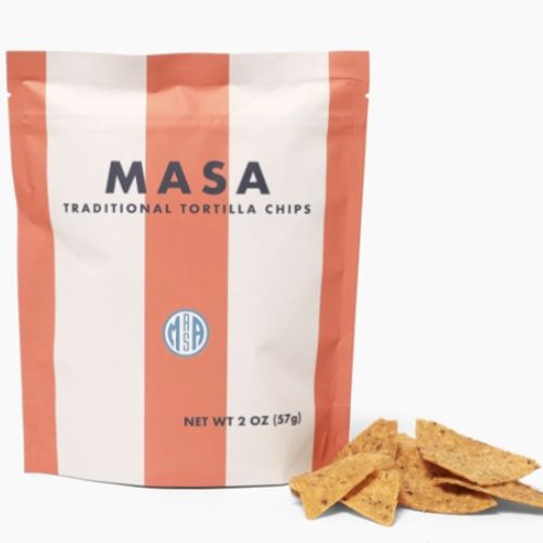 A bag labeled "MASA Traditional Tortilla Chips" with several chips beside it. Net weight is 2 oz (57g).
