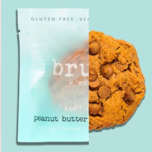 The image shows a package labeled "gluten-free vegan peanut butter" and a cookie with chocolate chips peeking out from behind the package.