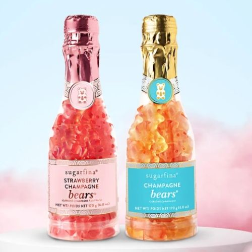 The image shows two bottles shaped like champagne bottles filled with sugarfina gummy bears, labeled "Strawberry Champagne" and "Champagne."